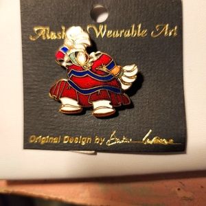 Handmade wearable Enamel art work. A Alaskan female dancing with feathers.